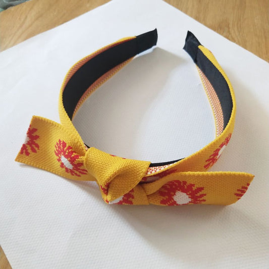 Bandeau à gros nœud en tricot avec marguerite