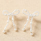 Pendants d'oreilles en forme de nœud papillon avec perles blanches