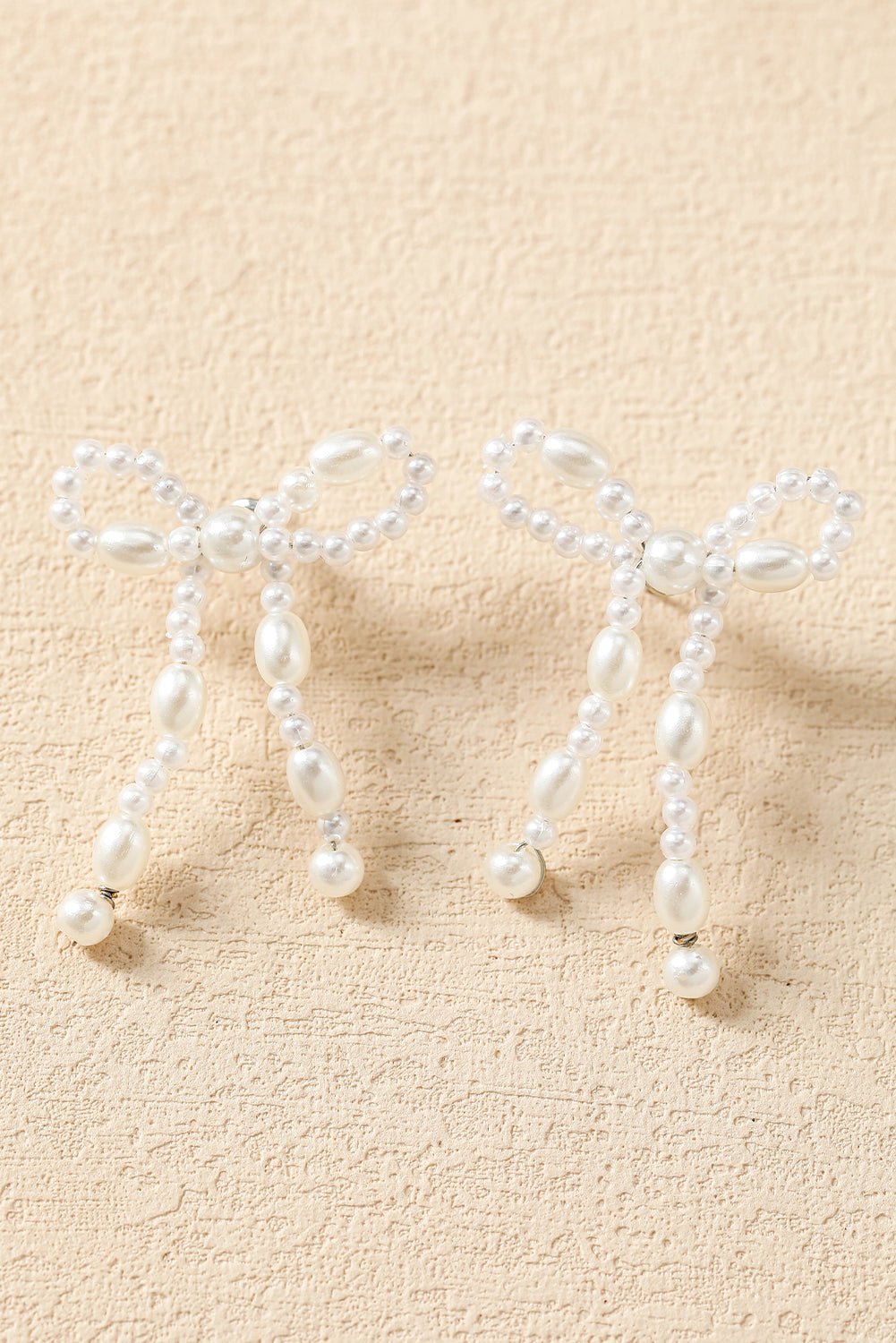 Pendants d'oreilles en forme de nœud papillon avec perles blanches