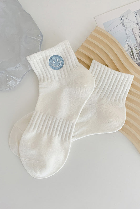 Chaussettes en coton brodées d'un joli visage souriant, bleu clair