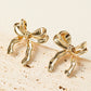 Boucles d'oreilles en forme de noeud avec ruban élégant en or