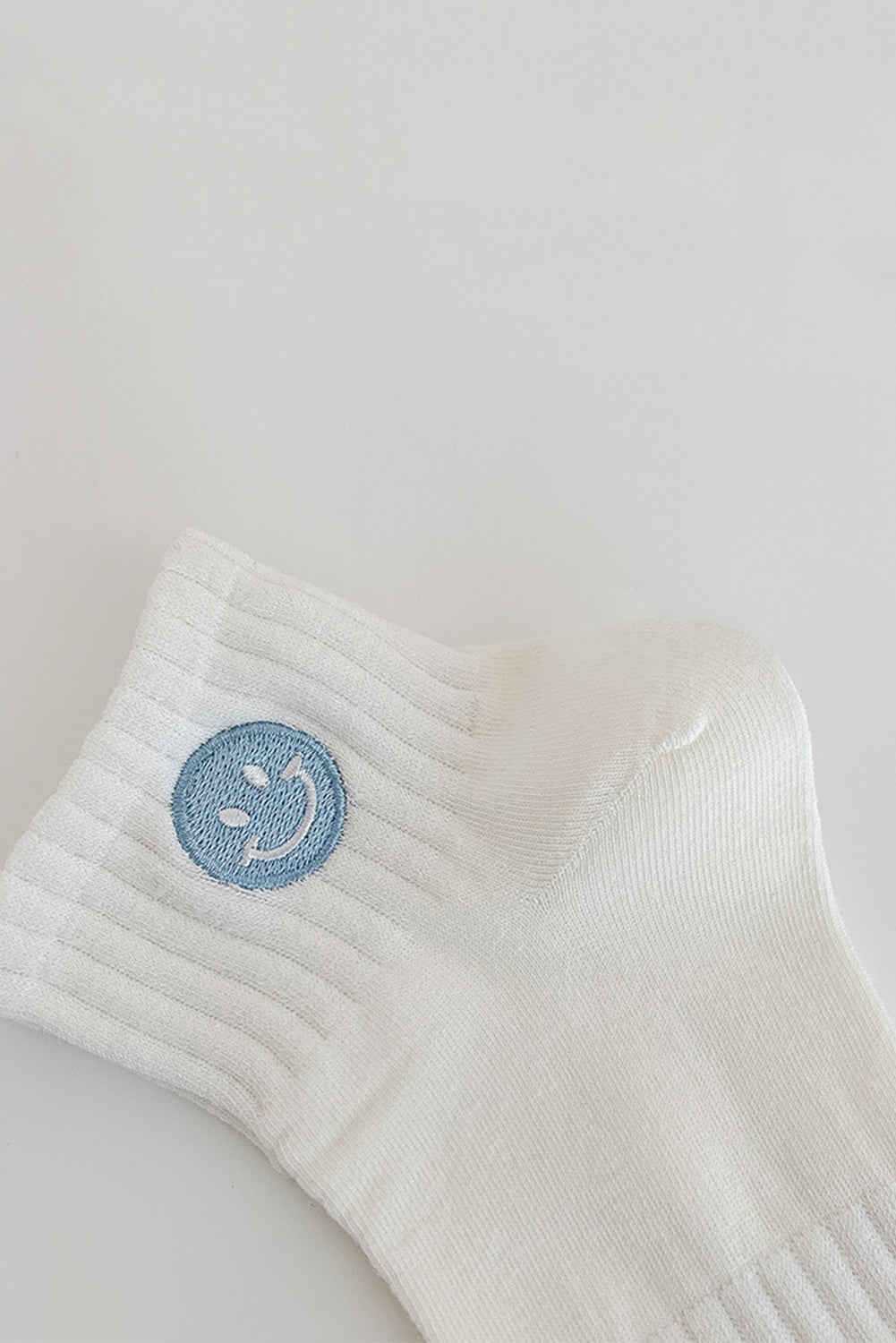 Chaussettes en coton brodées d'un joli visage souriant, bleu clair