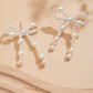 Pendants d'oreilles en forme de nœud papillon avec perles blanches