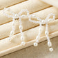 Pendants d'oreilles en forme de nœud papillon avec perles blanches